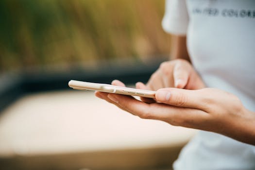 pexels-photo-369376-369376 Close-up of a person using a smartphone outdoors, focusing on hands and device.